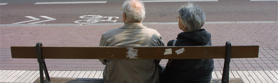 Illustrationsfoto af to ældre på en bænk fotograferet fra bagsiden af bænken